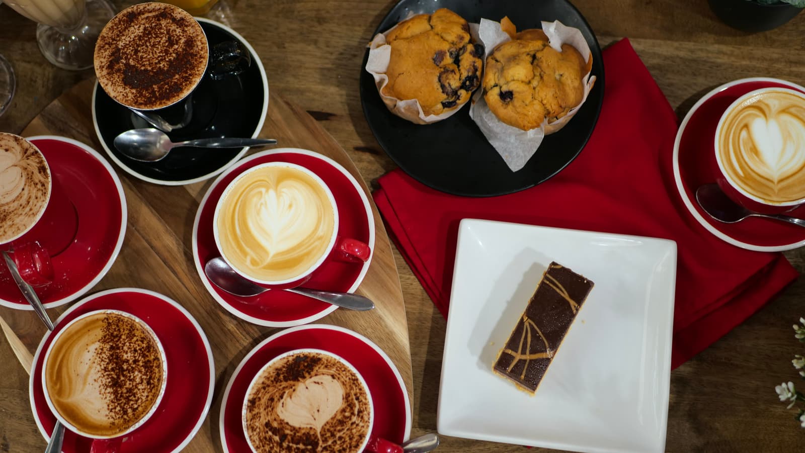 A spread of coffees, muffins and a caramel slice