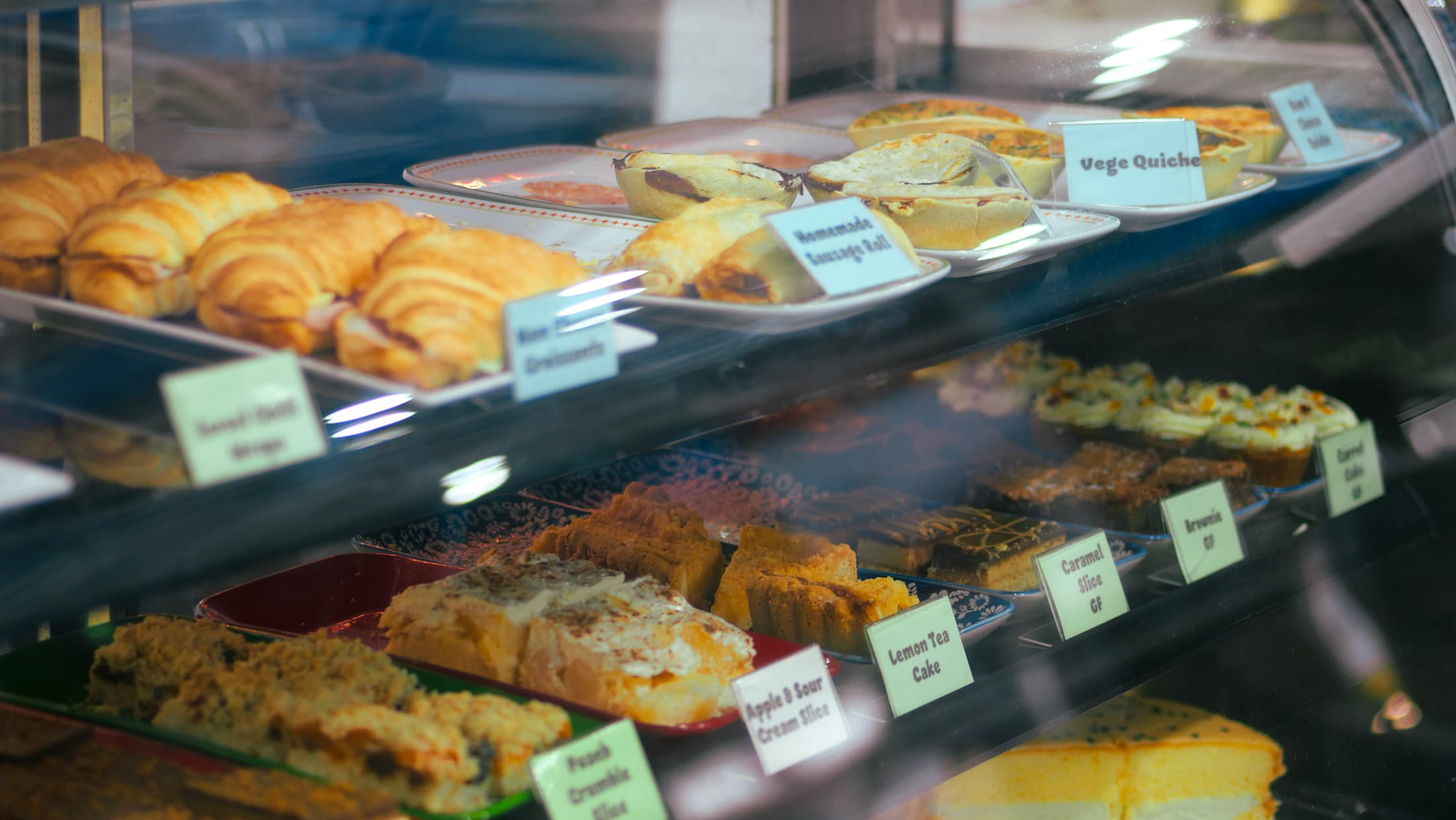The cake cabinet, stocked with croissants, slices and quiches