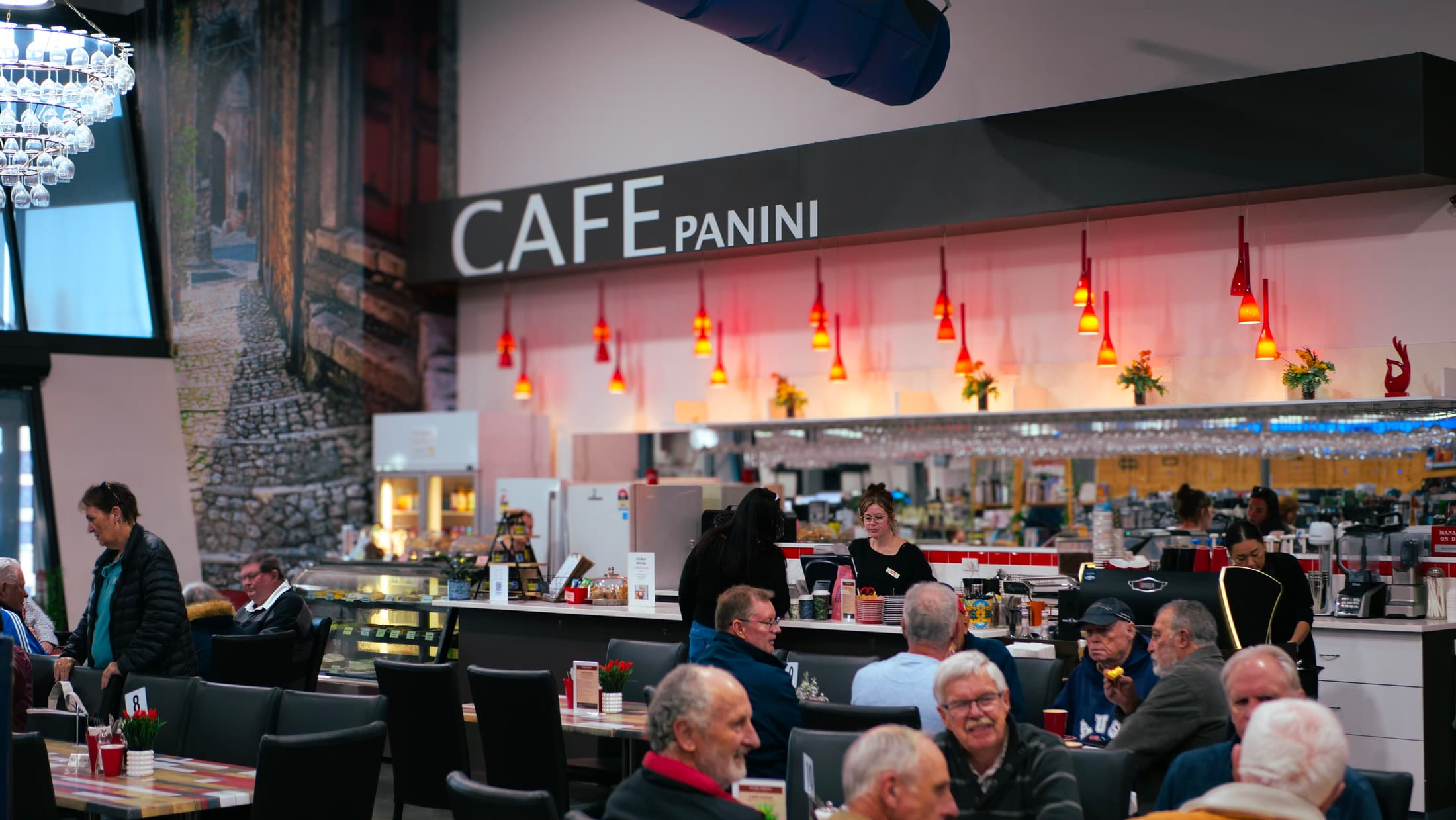 Inside Cafe Panini — customers at tables in front of the counter